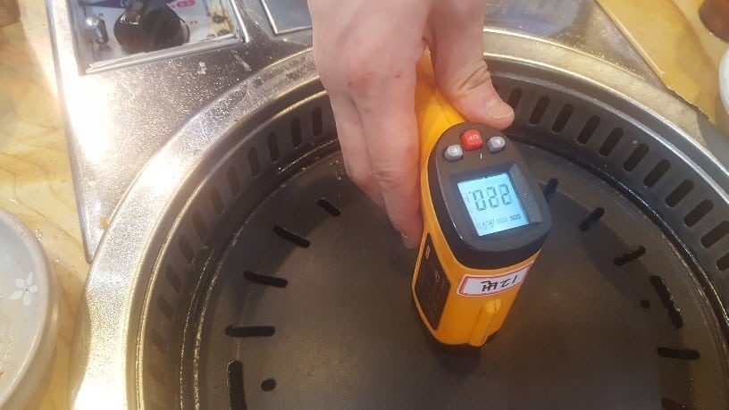 鉄板の温度を温度計で測っている写真